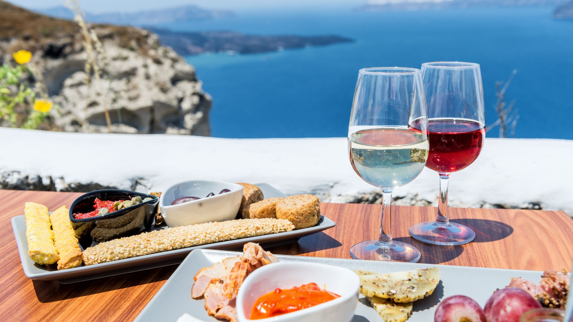 tavola apparecchiata di ristorante con prodotti tipici greci e vista sul mare